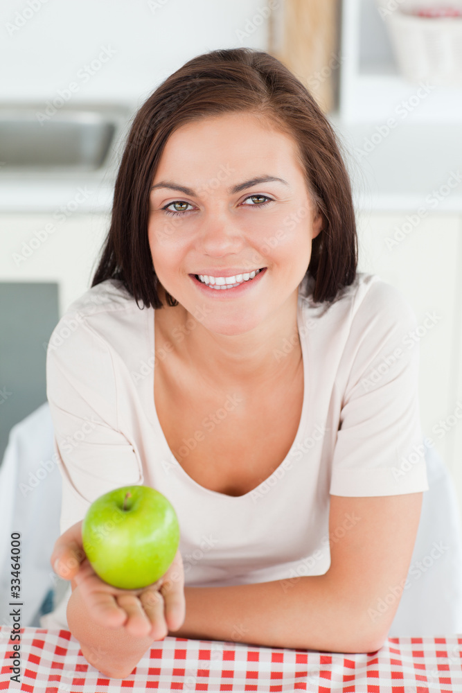 Laughing brunette showing an apple Laughing brunette showing an apple
