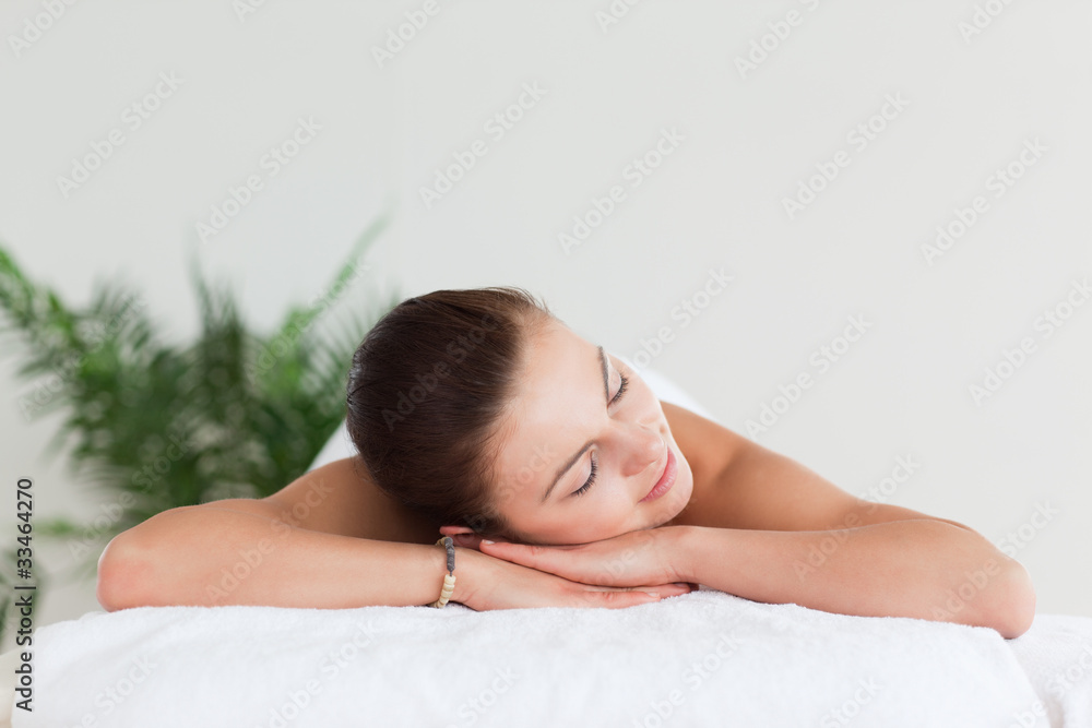 Young brunette lying on a massage table in a spa Young brunette lying on a massage table in a spa
