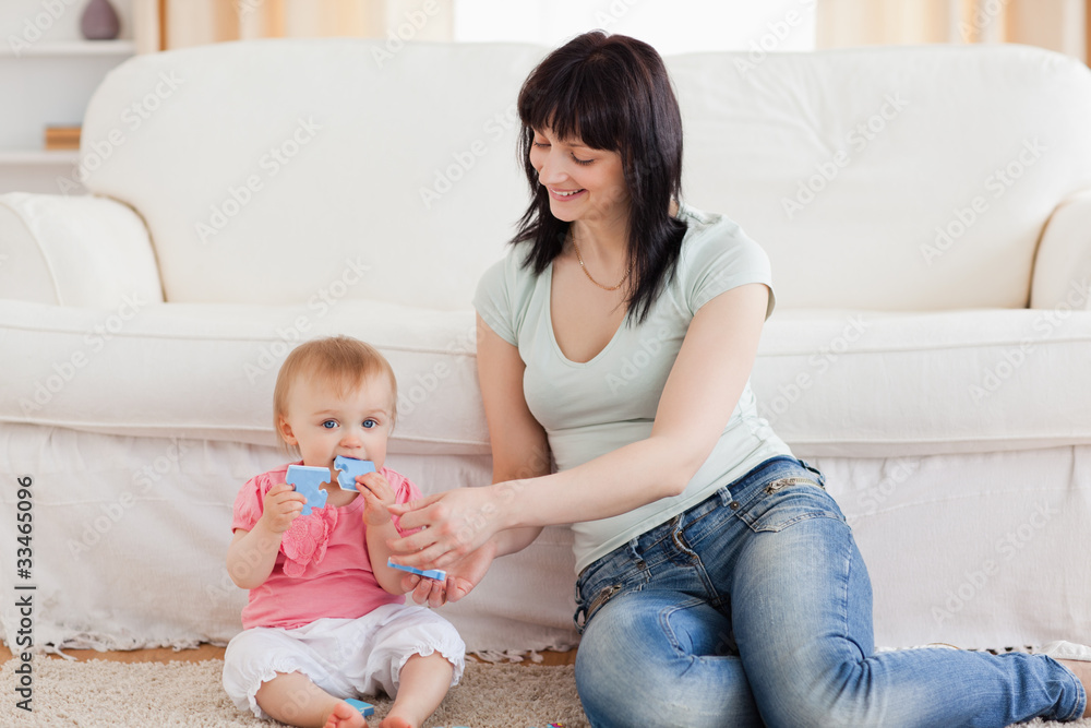 Attractive woman holding her baby in her arms while sitting on a Attractive woman holding her baby in her arms while sitting on a