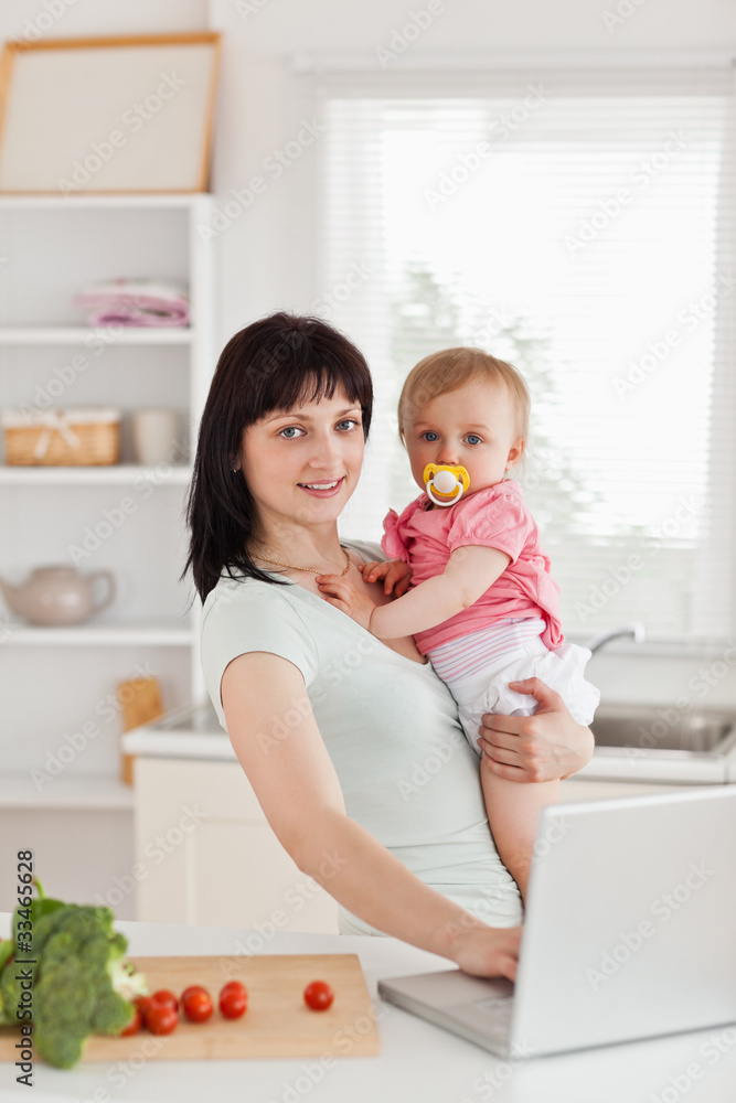 Beautiful brunette woman holding her baby in her arms Beautiful brunette woman holding her baby in her arms