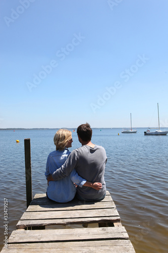 Couple sitting on the end of a pontoon