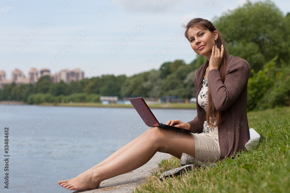 Young woman with laptop in the park.