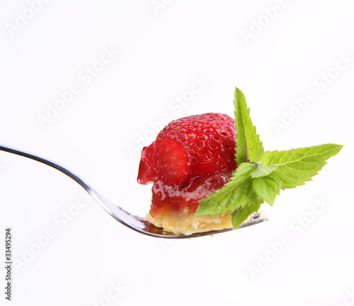 Piece of Strawberry Tart on a fork decorated with mint twig