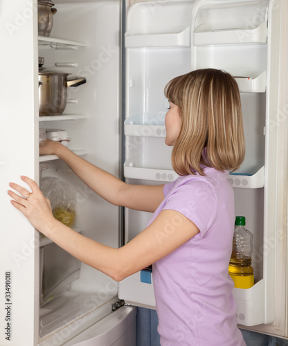 young  woman looking in  fridge