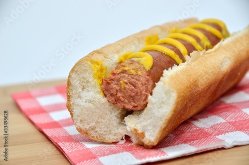 Hot dog with mustard partically eaten