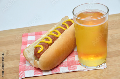 Hot dog with mustard and a glass of juice