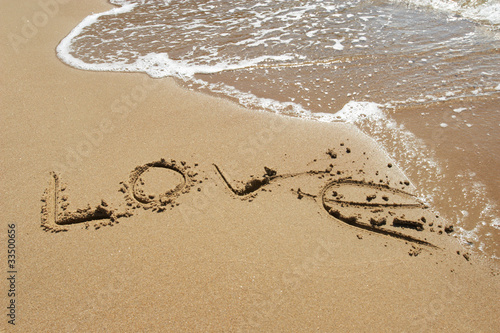 The inscription "love" on the sea sand