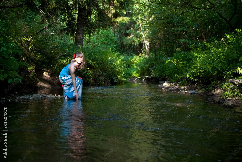 Fototapeta premium beautiful girl touches the water