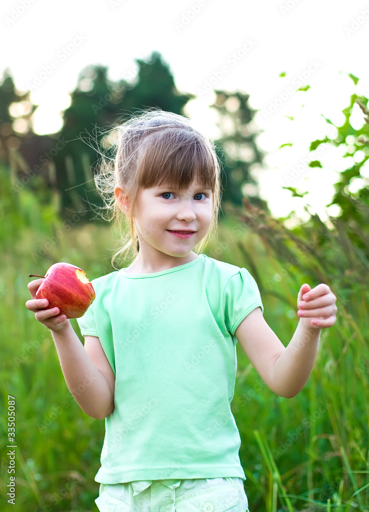 girl with apple in a meadow. summer time girl with apple in a meadow. summer time