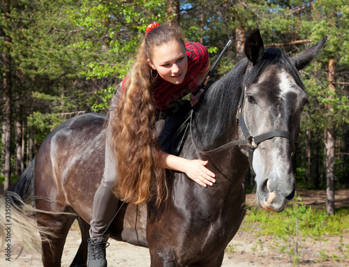 A girl with her hair stroking horse © aleksandrn