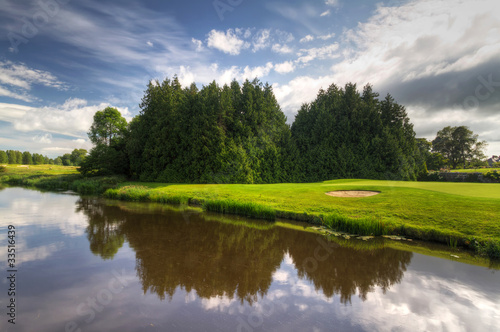 Fototapeta Naklejka Na Ścianę i Meble -  Idyllic golf course with reflection in the river