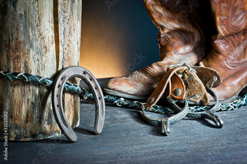 Cowboy boots,horseshoe,whip and spurs on wood photo