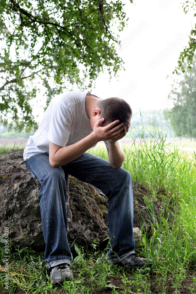 sad teenager sitting in the forest alone sad teenager sitting in the forest alone
