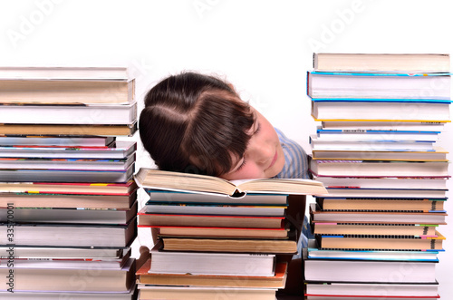 Girl tired of reading/studying sleeping among stacks of books