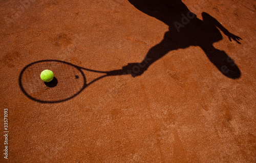 shadow of a tennis player in action on a tennis court © lightpoet