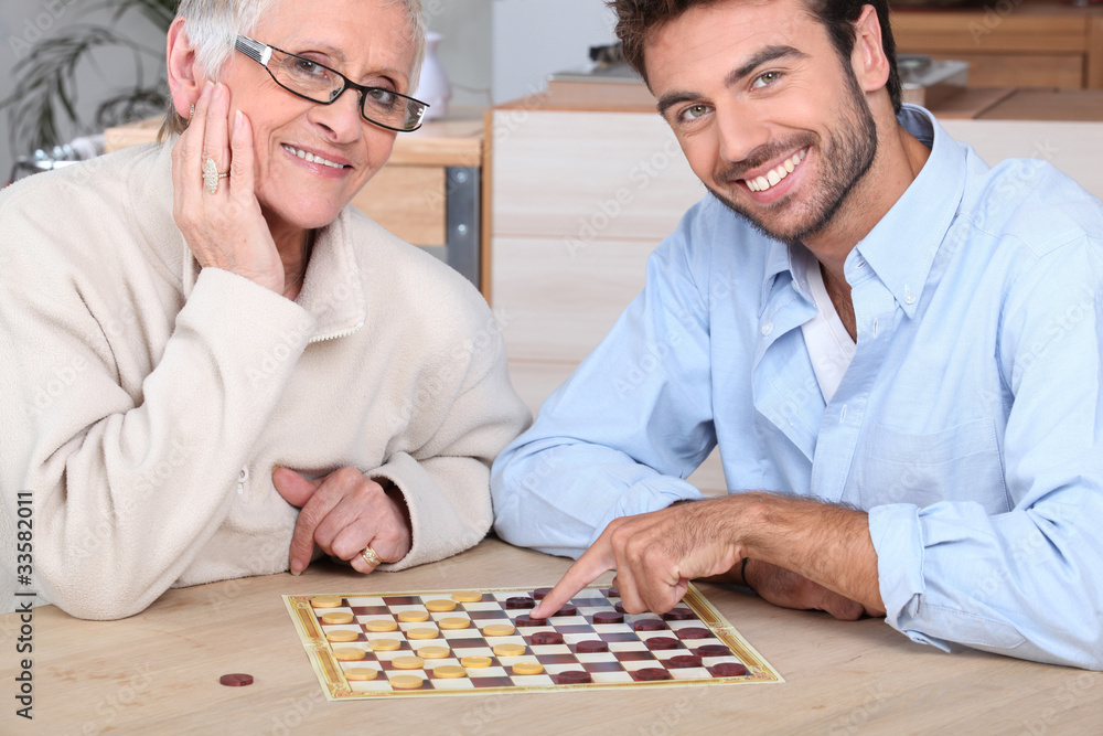 Fototapeta premium Young man playing game with elderly woman