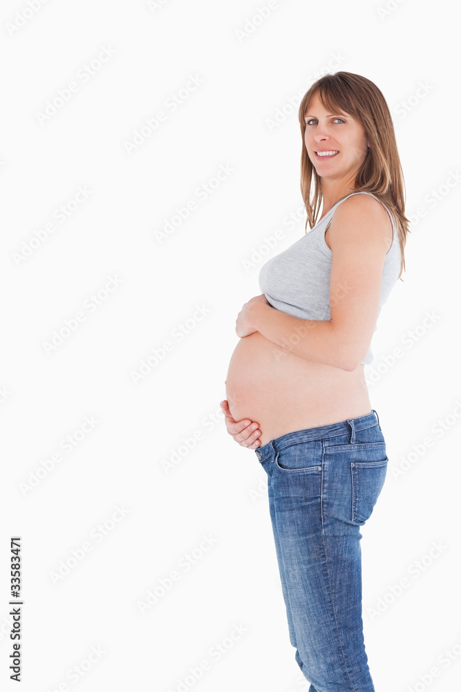 Side view of a good looking pregnant woman caressing her belly w Side view of a good looking pregnant woman caressing her belly w