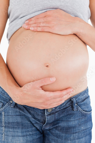 Close-up of a pregnant woman caressing her belly while standing © WavebreakmediaMicro