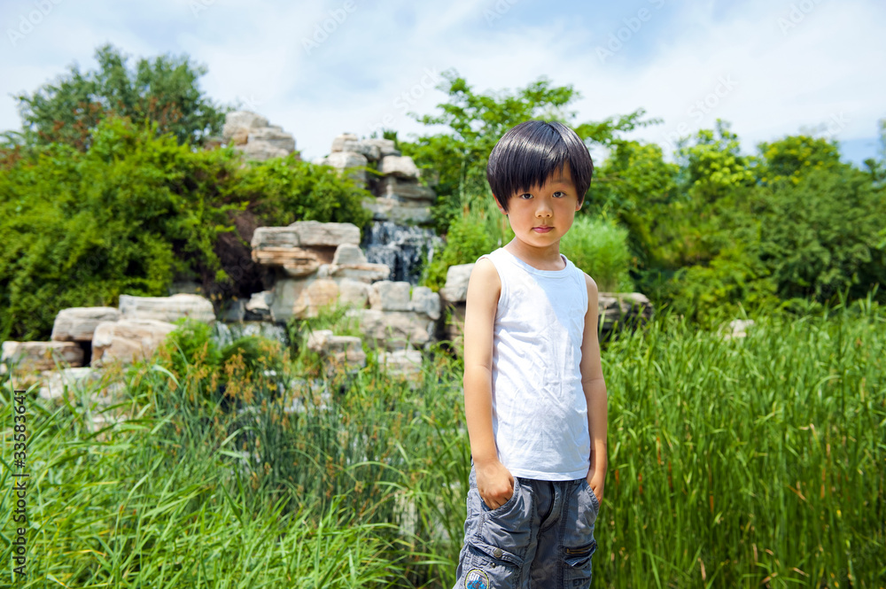 Cute Chinese boy outdoor in white shirt (in front of waterfall) Cute Chinese boy outdoor in white shirt (in front of waterfall)