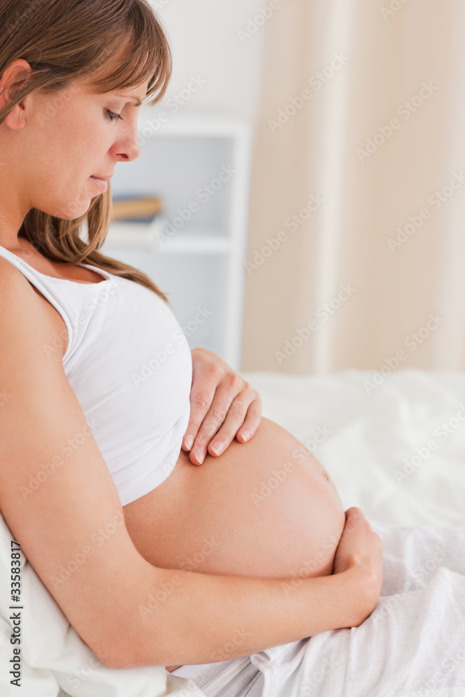 Portrait of a charming pregnant female lying on a bed Portrait of a charming pregnant female lying on a bed