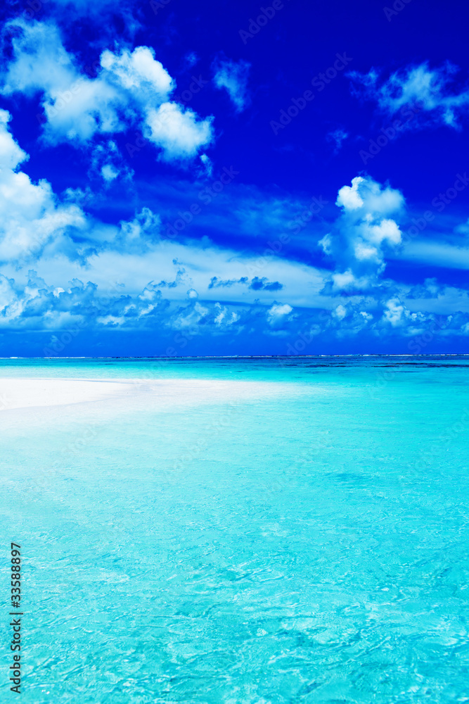 Empty beach with blue sky and vibrant ocean