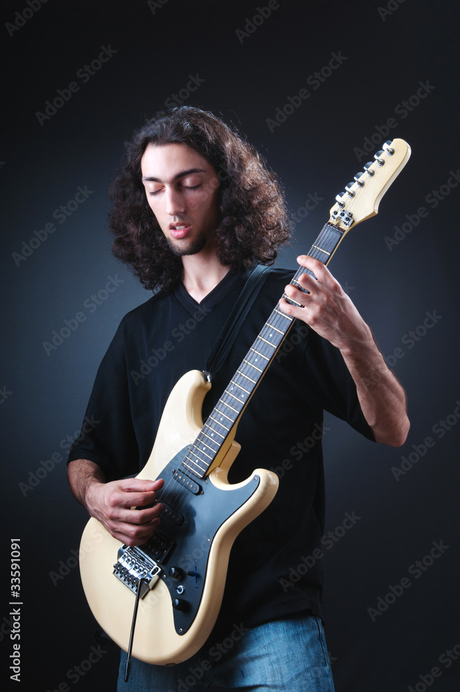 Obraz premium Guitar player against the dark background