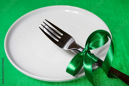 white plate with knife and fork with green gibbon over green bac
