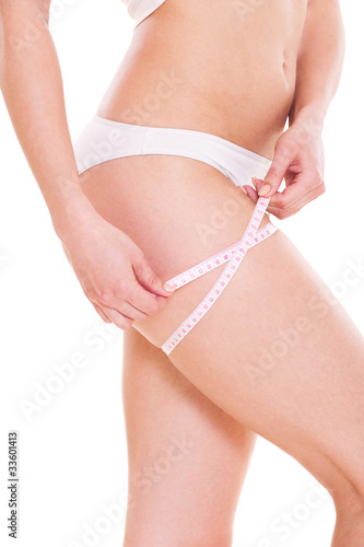 slim woman measuring her hip