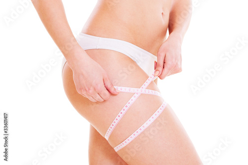 slim woman measuring her hip
