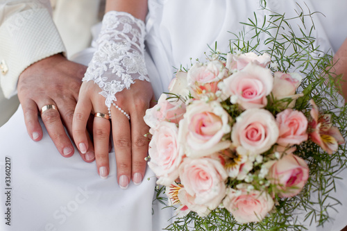 Hands and rings with wedding bouquet