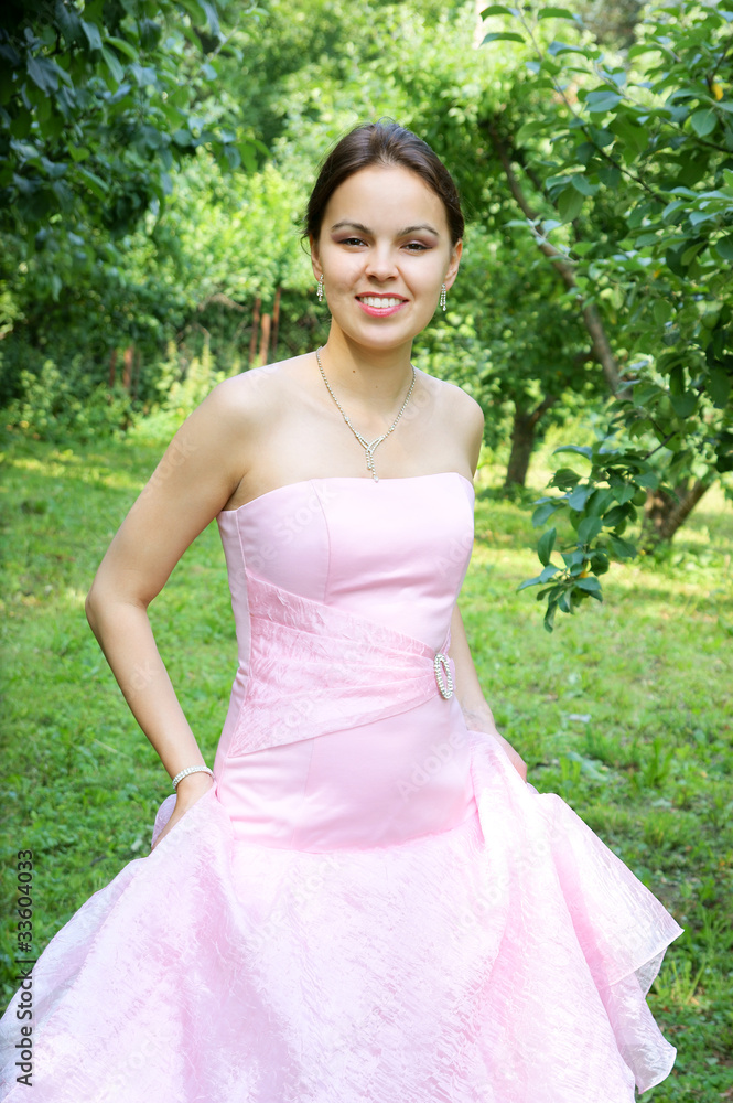 Young woman in pink dress near trees Young woman in pink dress near trees