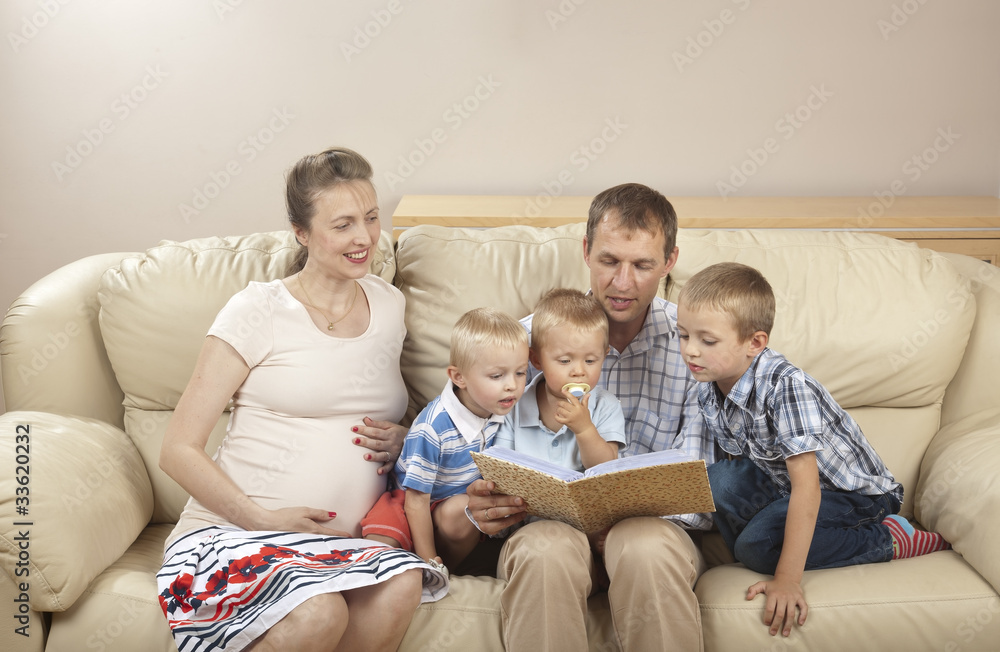 Family sitting on the sofa and watching photo album Family sitting on the sofa and watching photo album