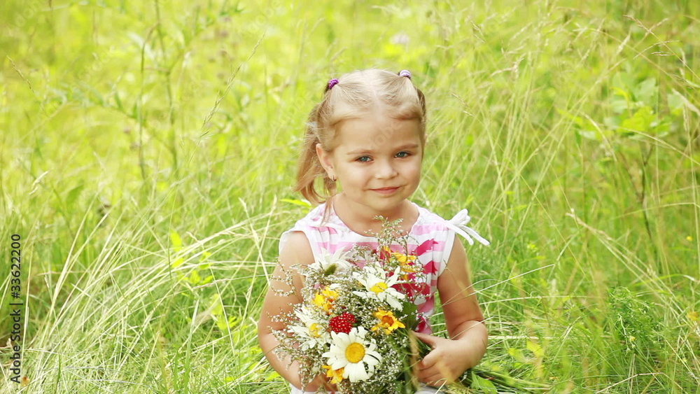 Portrait of a little girl on grass with flowers. Portrait of a little girl on grass with flowers.