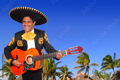 Charro mexican Mariachi playing guitar in beach