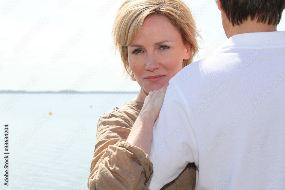 Mature couple hugging by the water