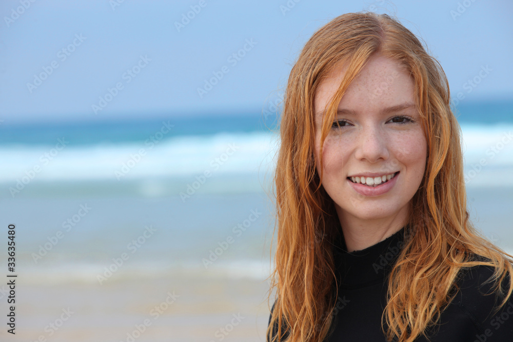 Teenage girl on beach in wetsuit Teenage girl on beach in wetsuit