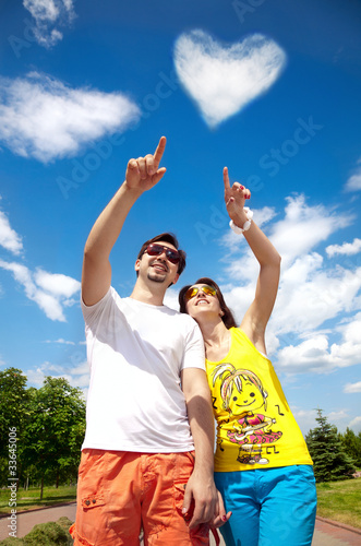 Couple pointing at cloud heart