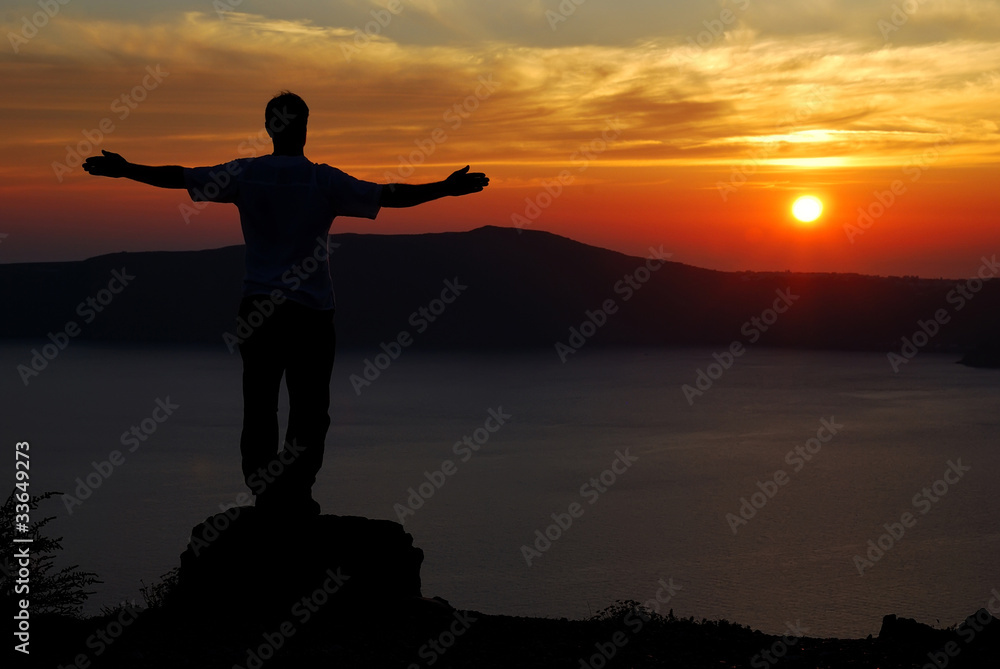 Man on Santorini sunset over the coastline