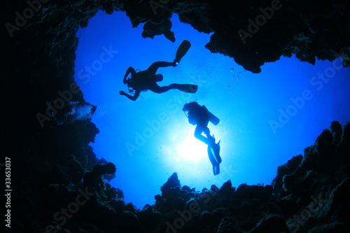 Scuba Divers descend into an underwater canyon
