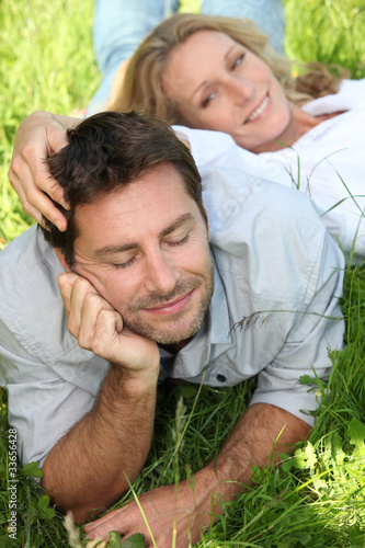 Fotografie Couple lazing in the grass