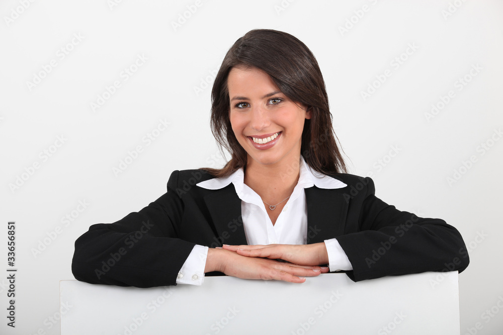 Businesswoman leaning on a board left blank for your message Businesswoman leaning on a board left blank for your message