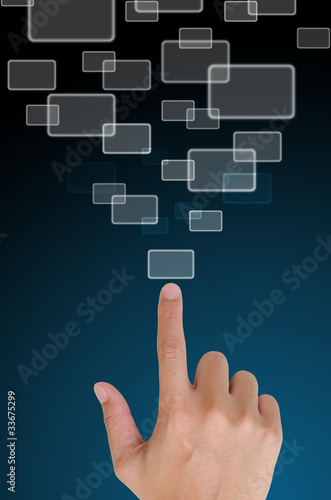 Hand pushing a button on a touch screen interface in wide world.