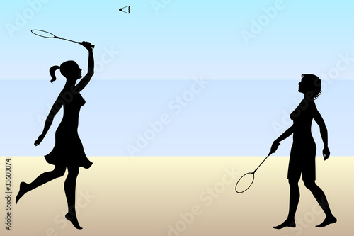 Two girls playing badminton on beach