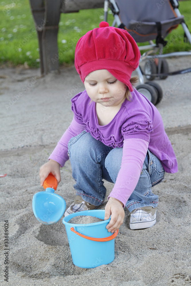 Little girl playing with sand on a playground Little girl playing with sand on a playground
