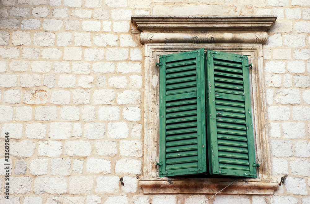 Window with green shutters in old wall (Italia)