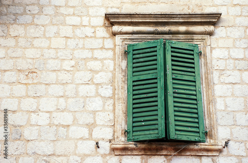 Window with green shutters in old wall (Italia)