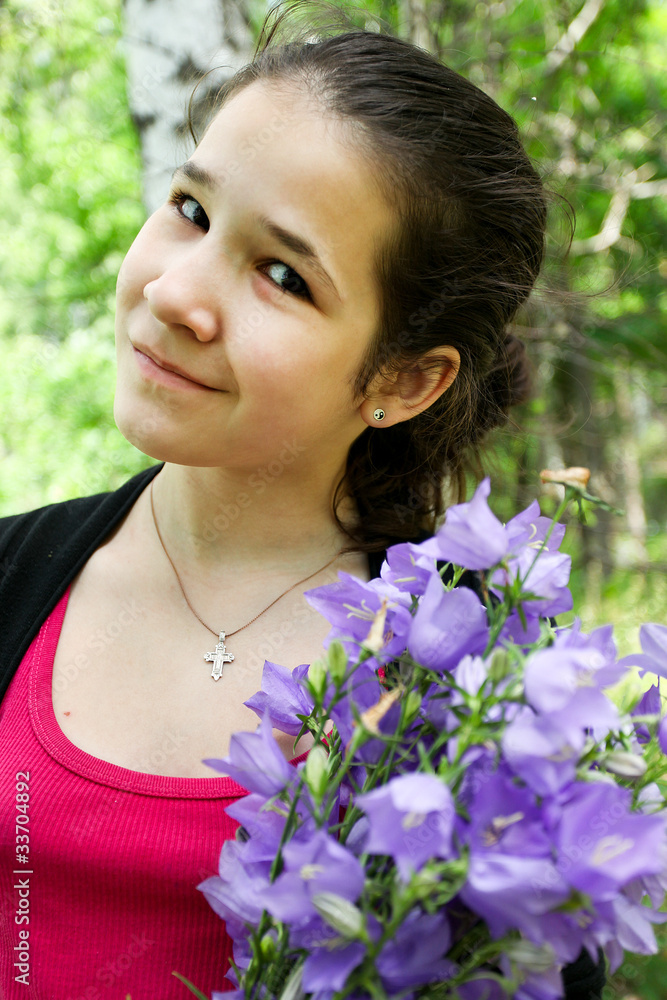 Happy young girl with brigth bluebell flowers in beautiful bunch Happy young girl with brigth bluebell flowers in beautiful bunch