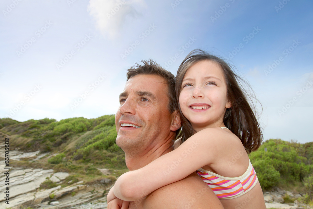 Father carrying daughter on his shoulders Father carrying daughter on his shoulders
