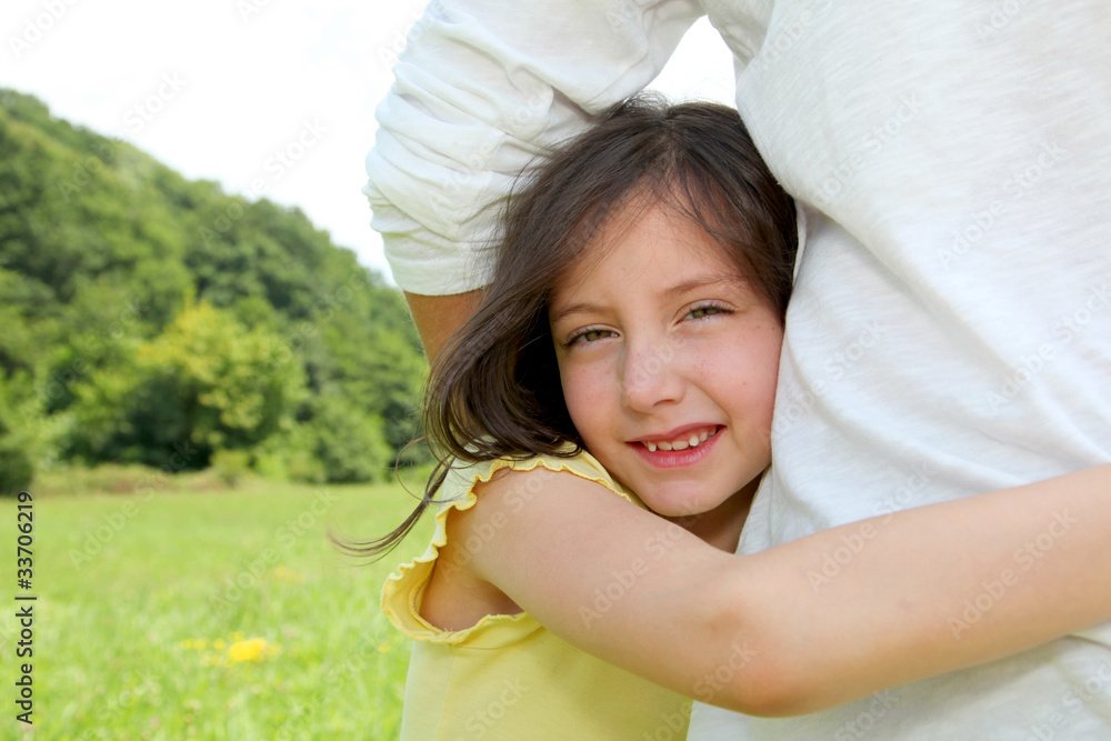 Little girl putting her arms around her father's waist Little girl putting her arms around her father's waist