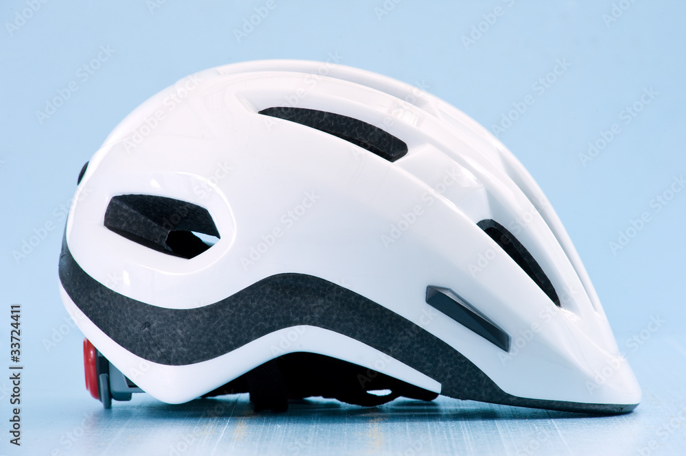 White bike helmet isolated on blue background. Lateral view. White bike helmet isolated on blue background. Lateral view.